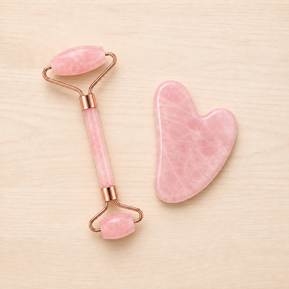 A rose quartz facial roller beside its matching heart-shaped gua sha